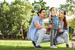 parents with daughter blowing bubbles