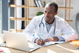 male doctor working at laptop