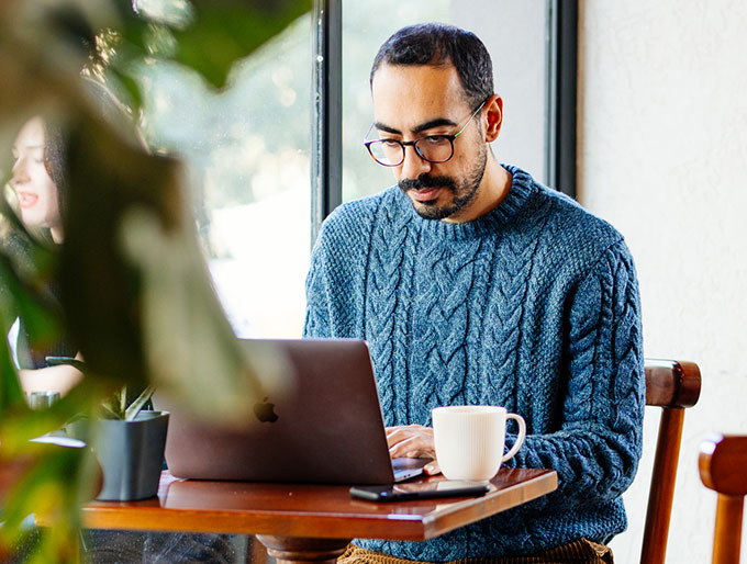 man working on laptop with coffee