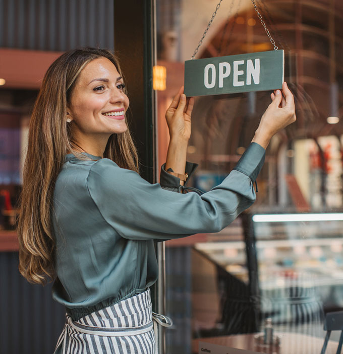 Woman with open sign in business window