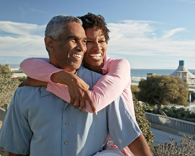 smiling couple traveling near beach