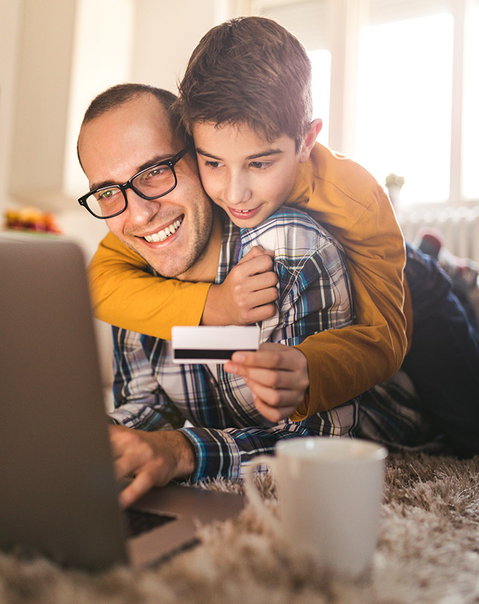 man with son holding credit card shopping online